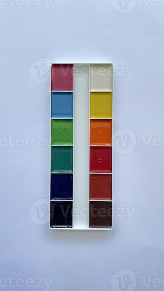 Bright Watercolor Paint Set on White Background. Top View of Colorful Artistic Supplies for Creative Work, School Projects, and Drawing. Minimalist Flat Lay of Paint Palette. photo