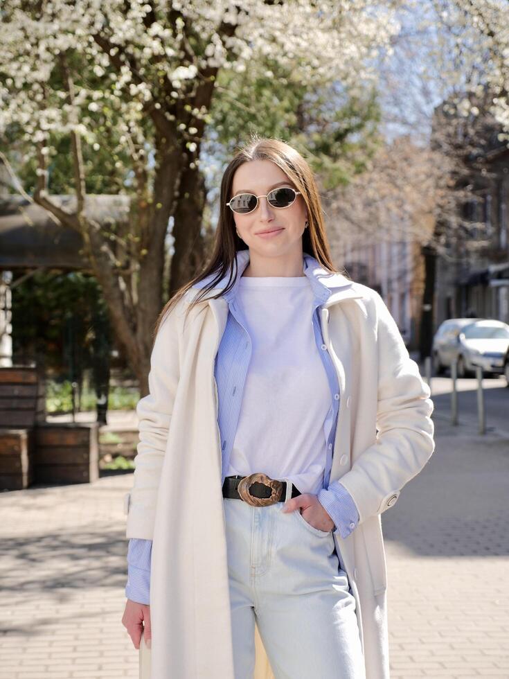 woman in white coat and sunglasses outdoors photo