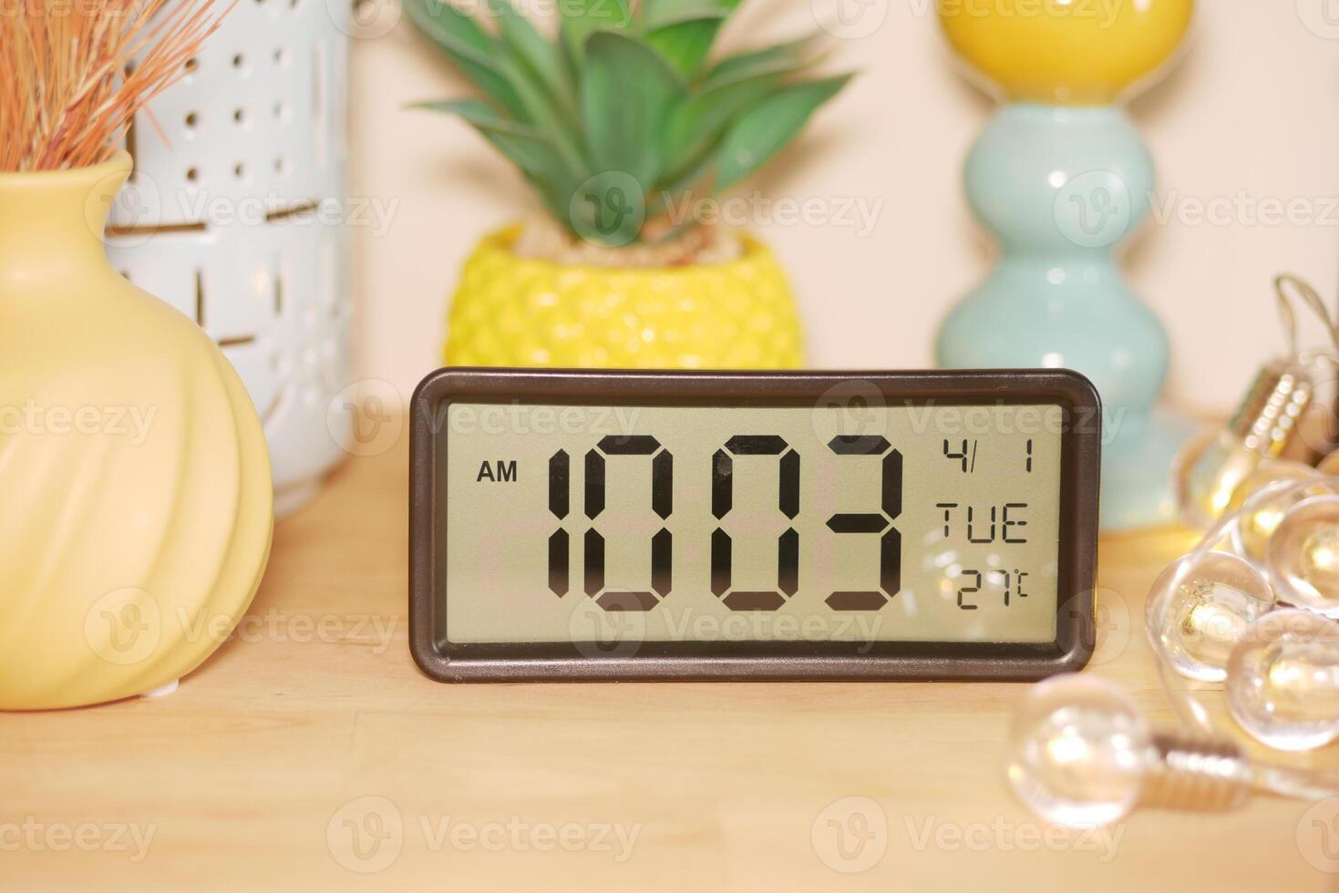 Digital clock displaying time and date on a wooden table photo