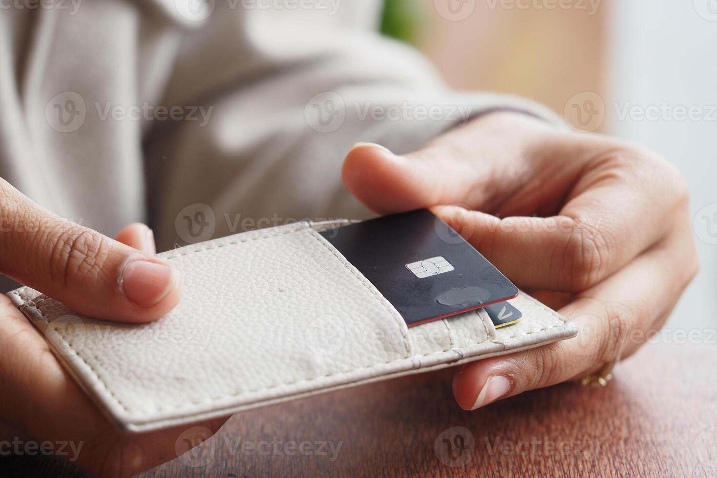 Individual holds a card in a wallet during daylight photo