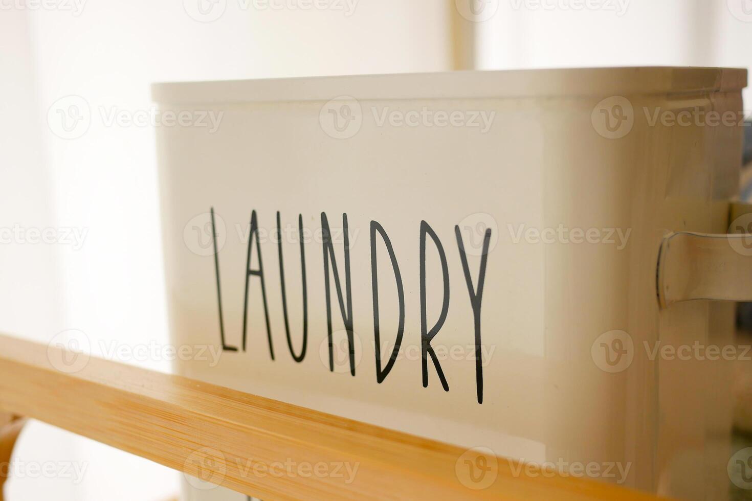Laundry basket placed on a wooden shelf in a bright room photo