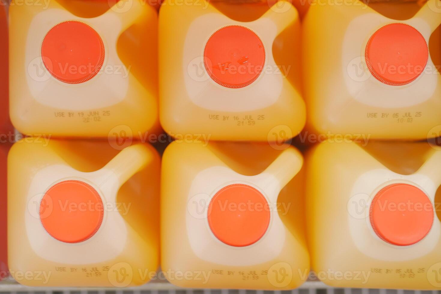 Bright orange juice containers on a grocery store shelf photo