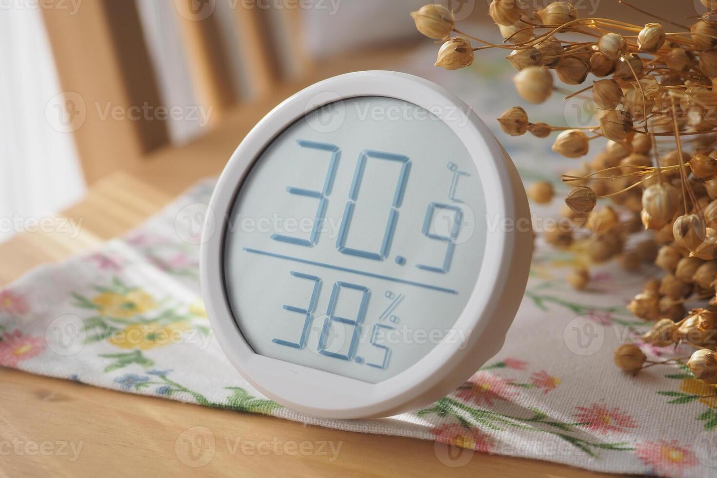 Indoor temperature and humidity monitor on a wooden table photo