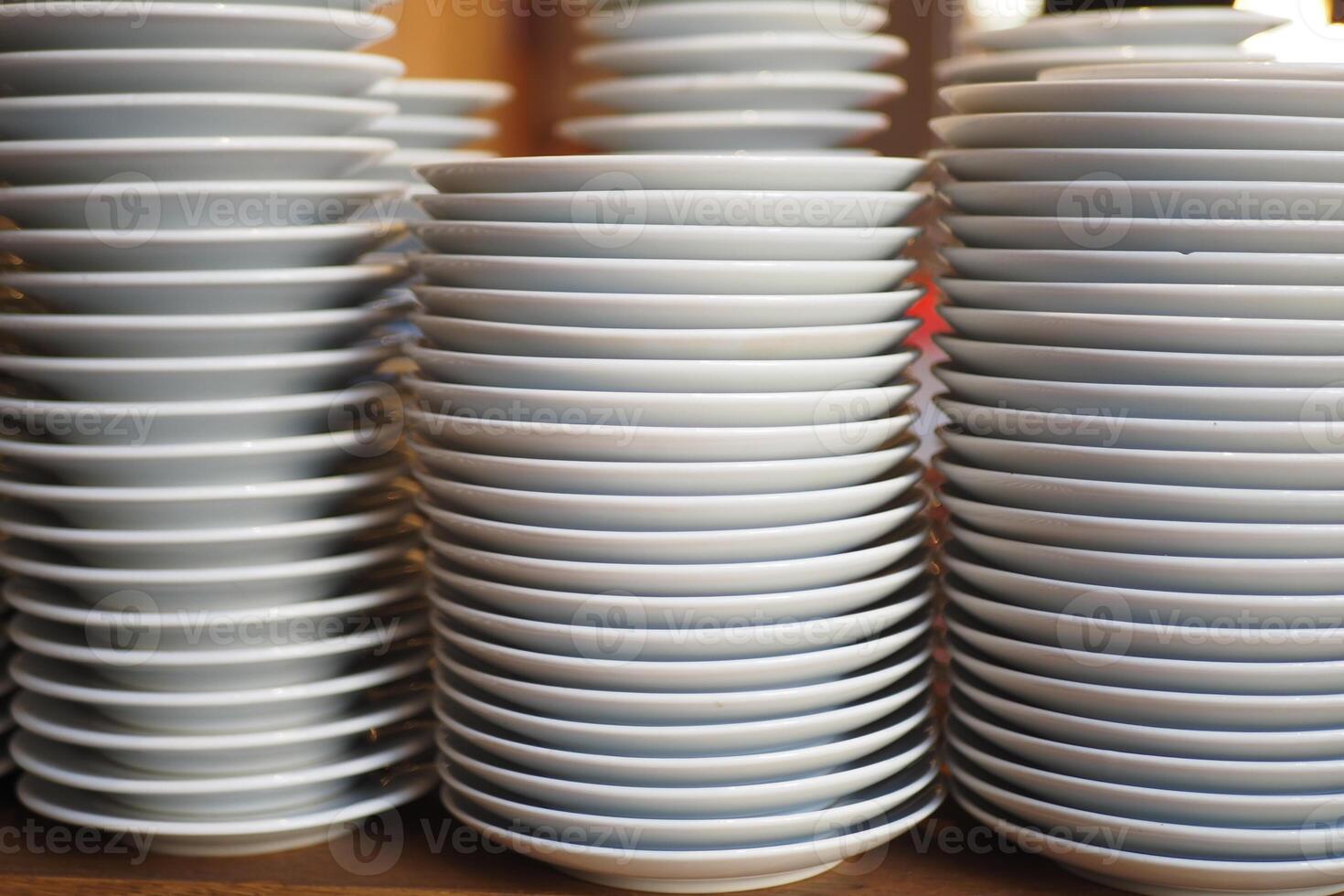 Stacked plates ready for serving in a busy kitchen photo