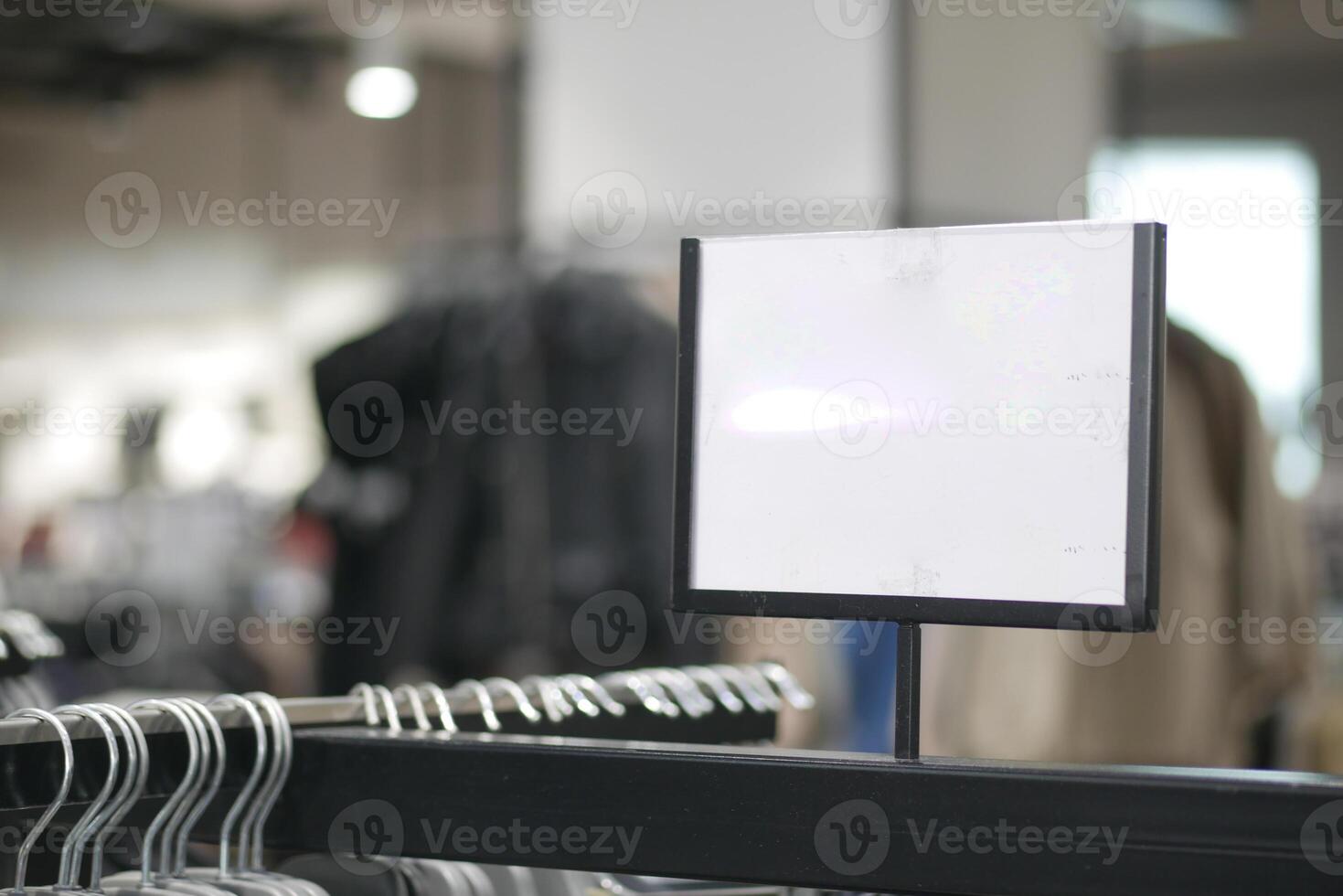 Black hanger rack in a clothing store with empty signage photo