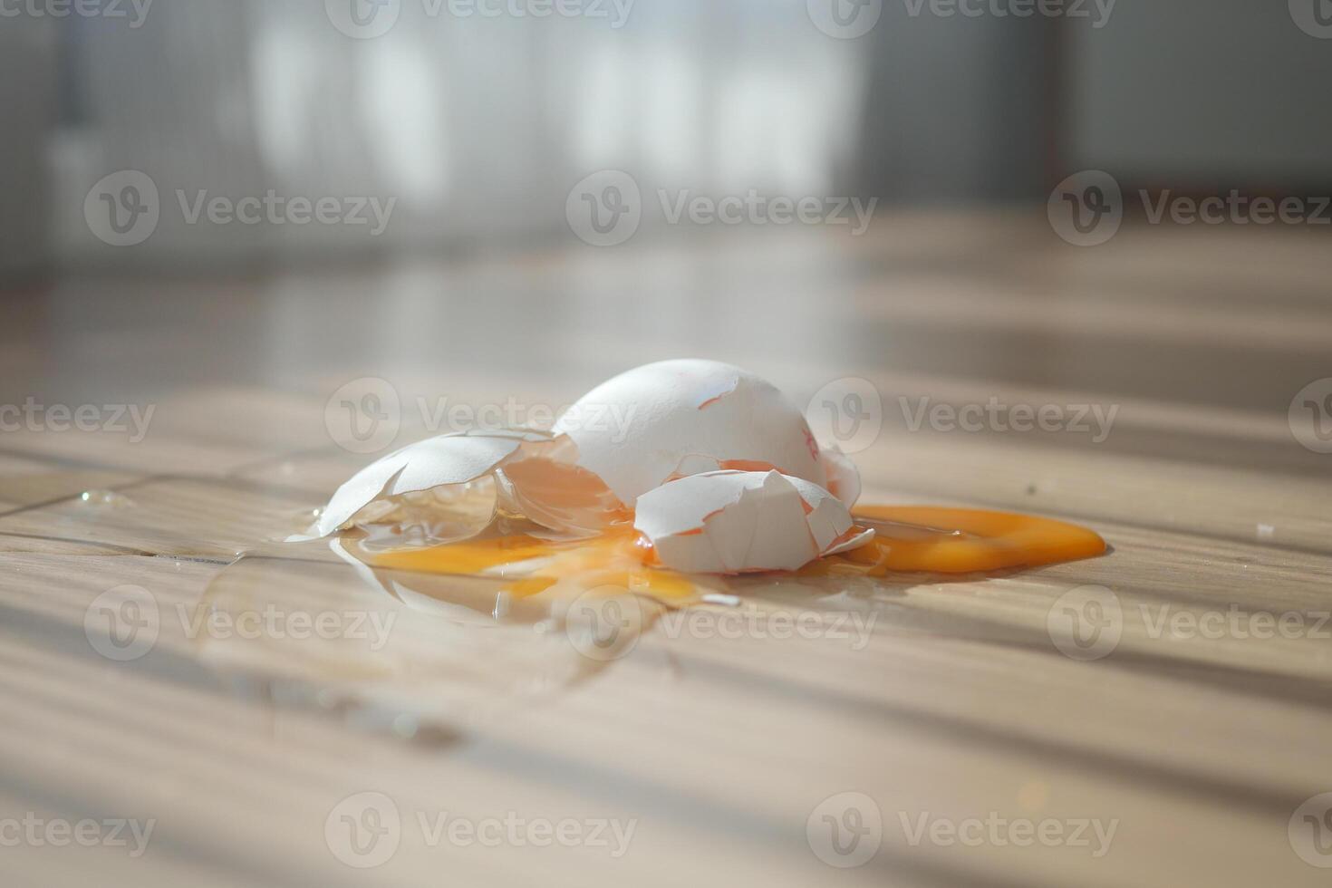 Egg shells and yolk spilled on wooden floor photo
