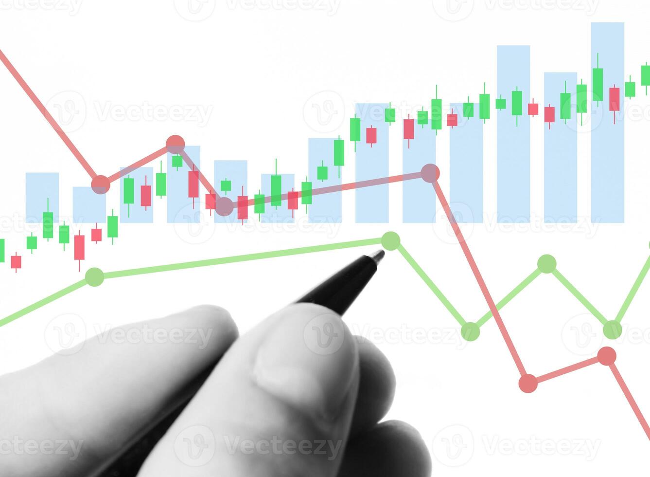 a hand is holding a pen and pointing at a chart photo