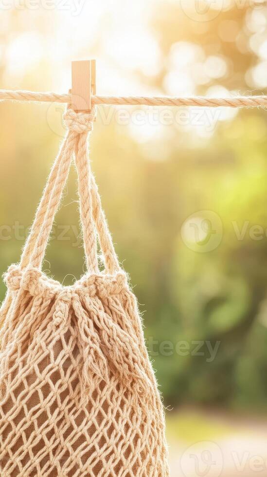 Mesh Bag Hanging from Rope with Clothespin in Sunlight. Concept of Waste Reduction and Ecological Living photo