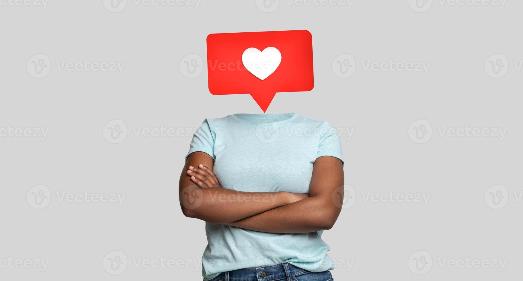 A person stands confidently with crossed arms, their head replaced by a large heart icon, symbolizing social media likes and positive engagement. photo