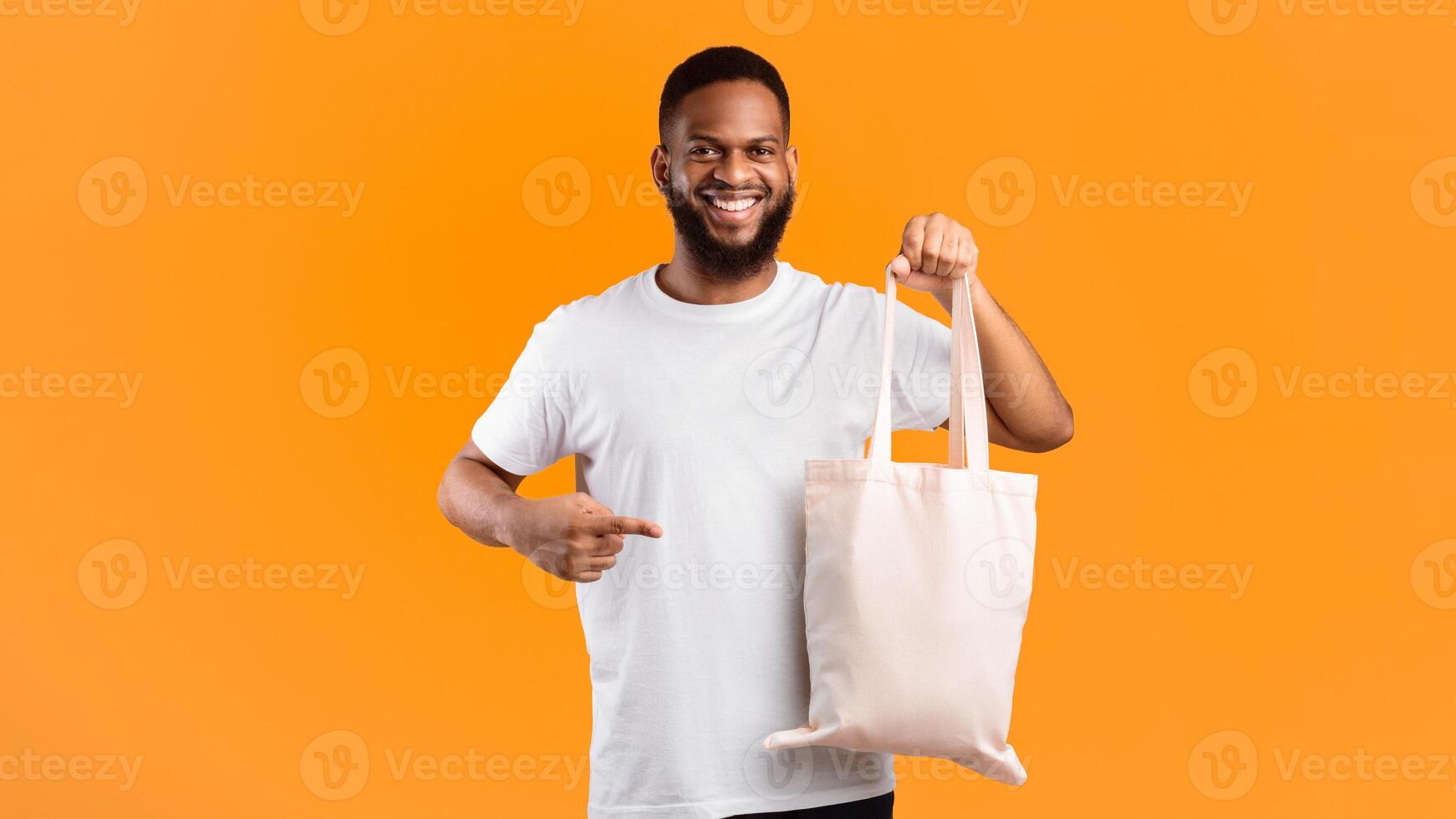 No More Plastic. Smiling Black Guy Holding Textile Eco Bag Standing Over Yellow Background In Studio. Ecology And Consumerism, Eco-Friendly Plastic-Free Lifestyle Concept. Panorama photo