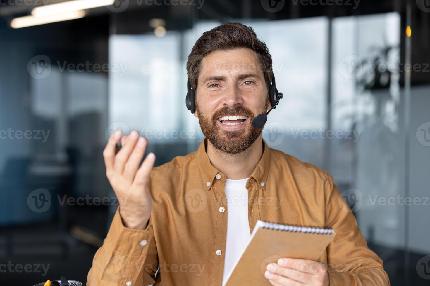 Business professional in virtual call demonstrating communication skills. Engaging expression, wearing headset, holding notebook. Ideal for concepts of remote work, virtual meetings, technology photo