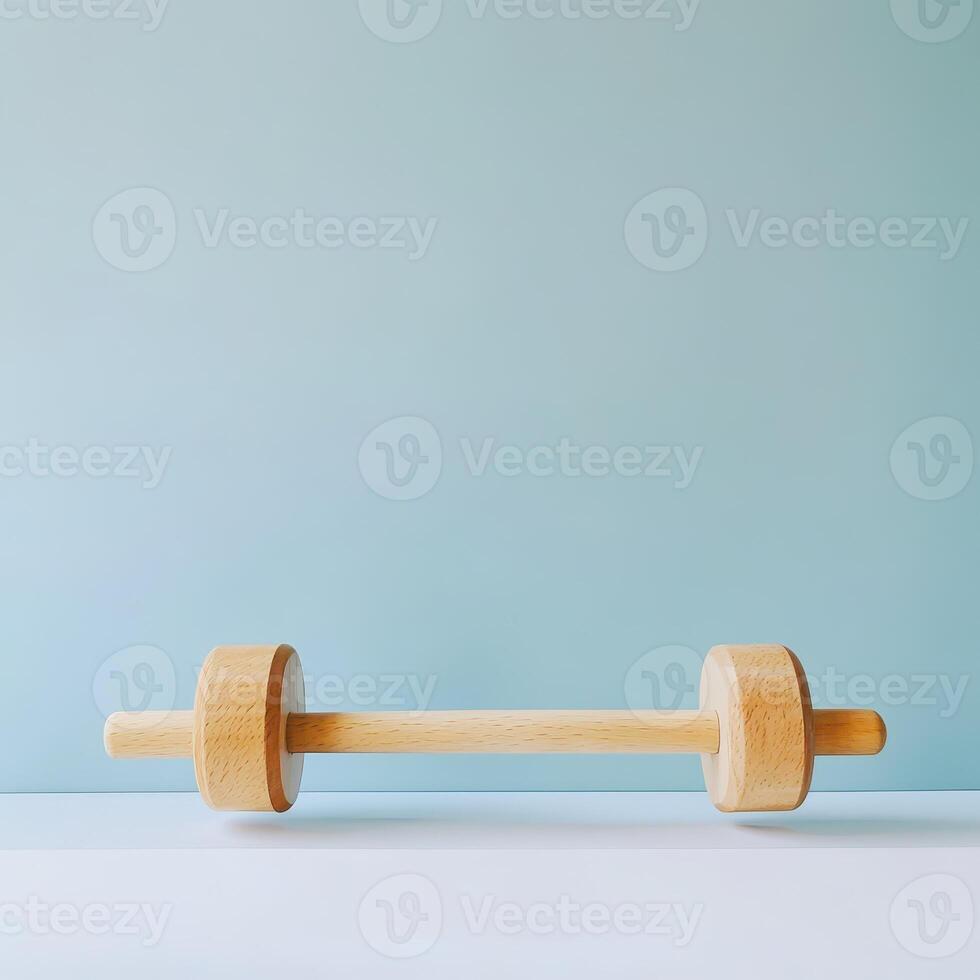 Wooden dumbbell on a minimalist background photo