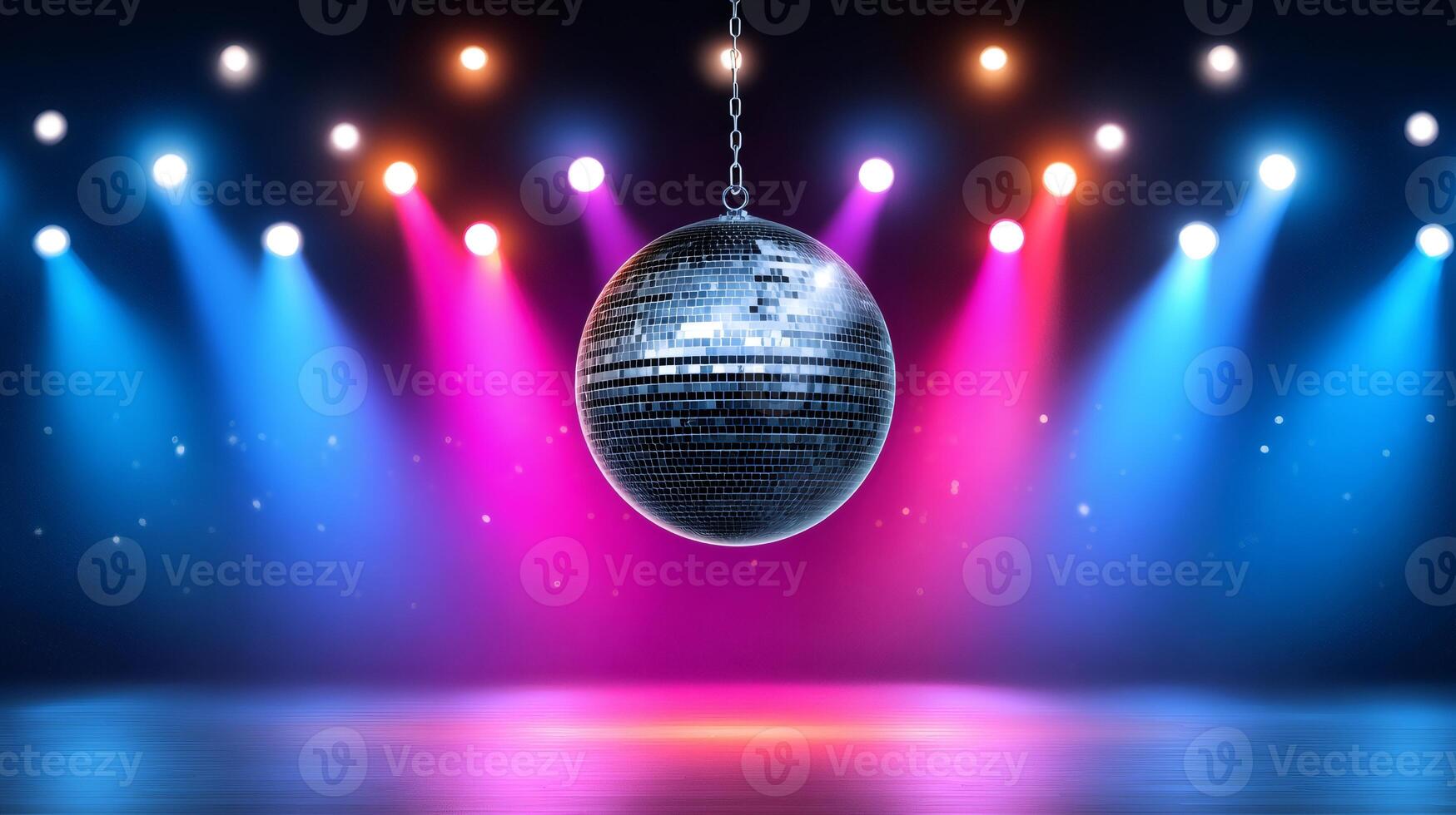 Disco ball hanging on stage with colorful spotlights shining photo