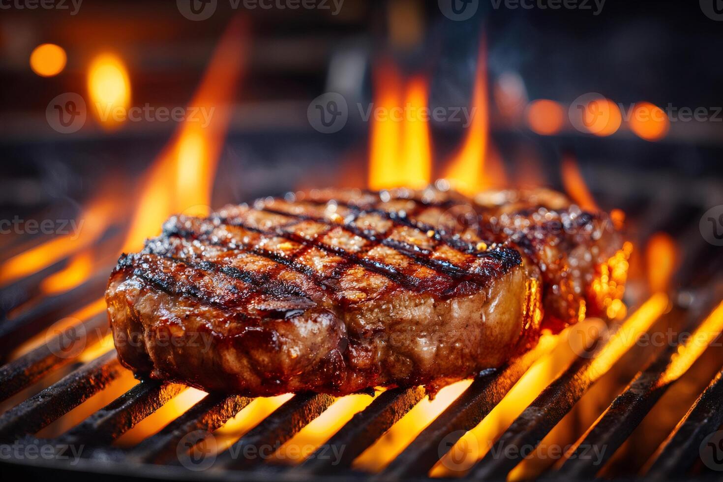 Juicy ribeye steak grilling over flames on a barbecue grill photo