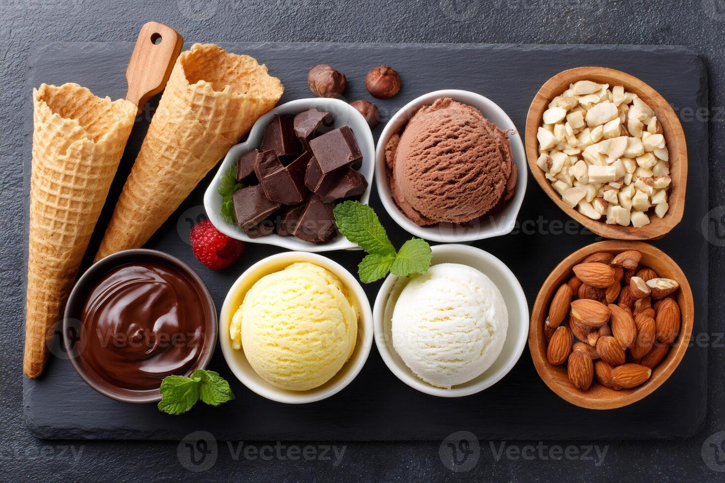 Ice cream assortment with chocolate, vanilla, chocolate sauce, and nuts is displayed on slate tray photo