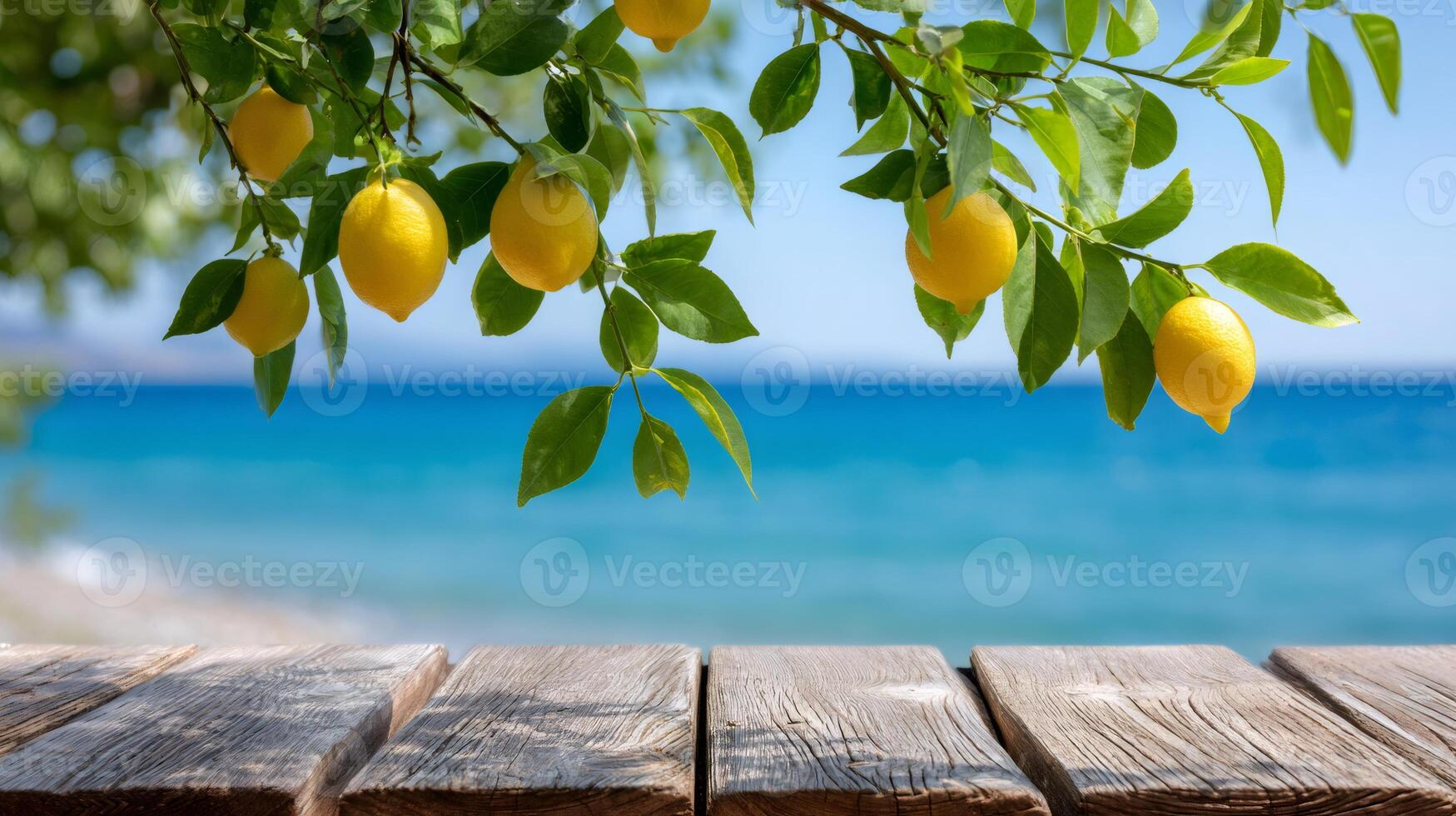 Ripe yellow lemons hanging from tree branch over wooden table with ocean view photo