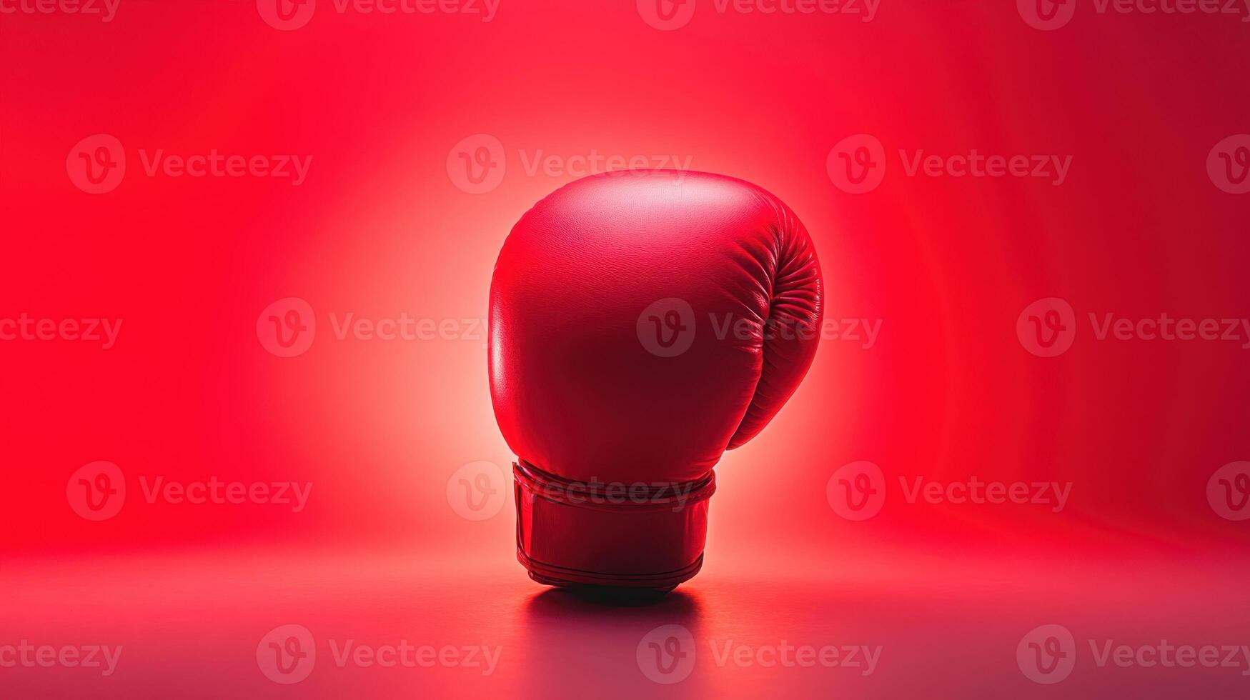 Red boxing glove stands prominently against a vivid red backdrop highlighting its texture and design during an evening training session in a gym photo