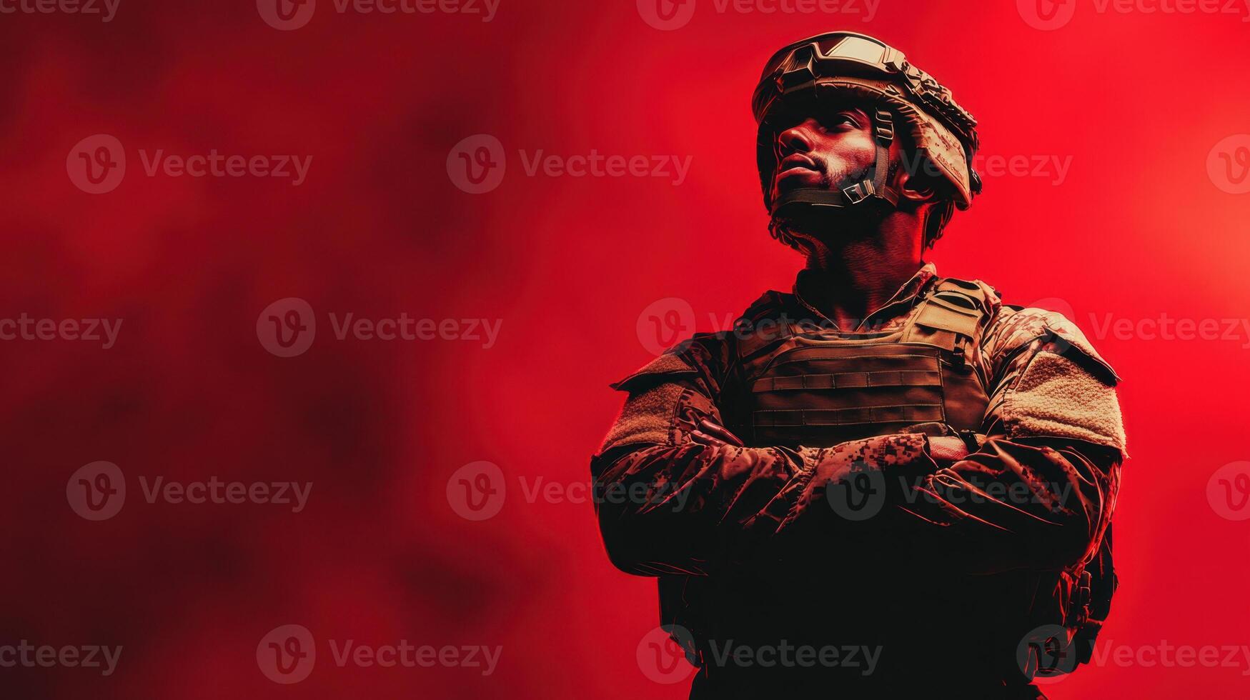 Soldier stands confidently in tactical gear against a vivid red background, embodying strength and determination during a dramatic moment of contemplation photo