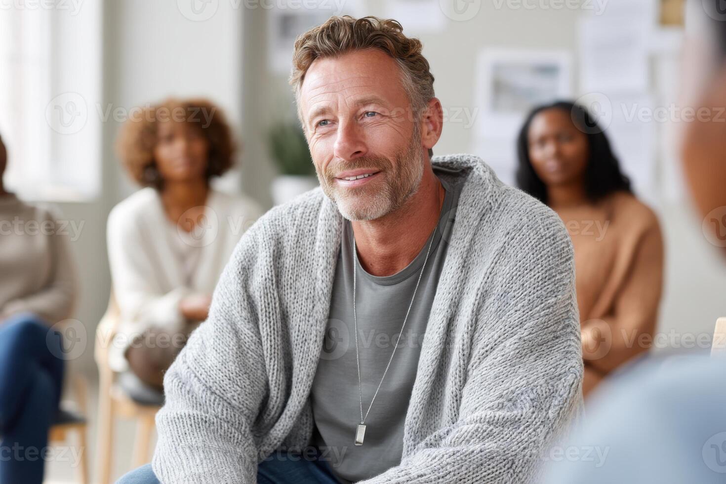 Caucasian man in his 50s listens empathetically at a support group for alcohol problems in a warm, bright room photo