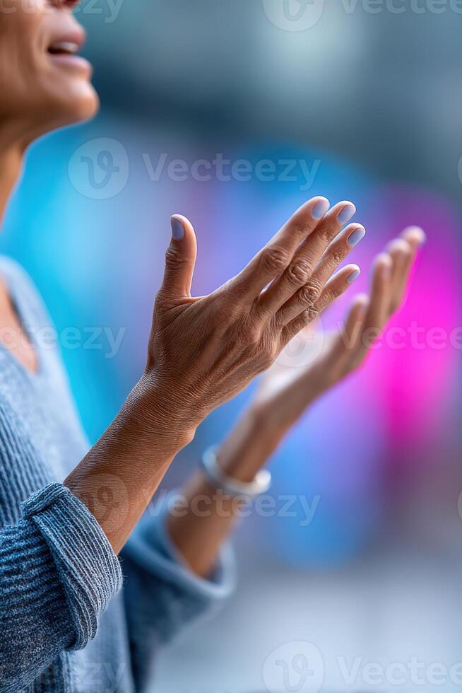 Hands gesturing passionately against a colorful backdrop during a lively speech event photo