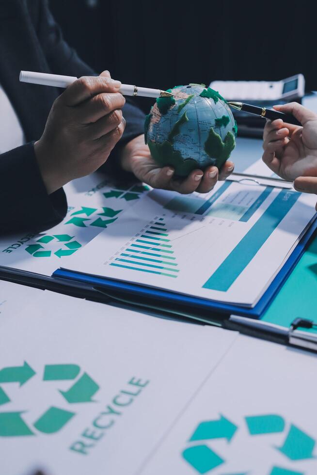 Recycle business concept with green recycling symbol and people working on paper photo