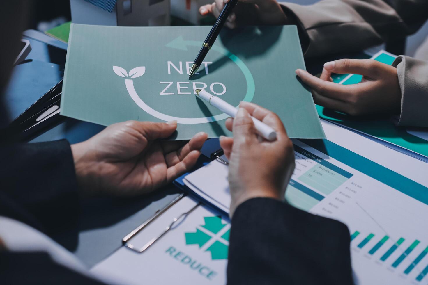 Business people working on a paper with the word net zero photo