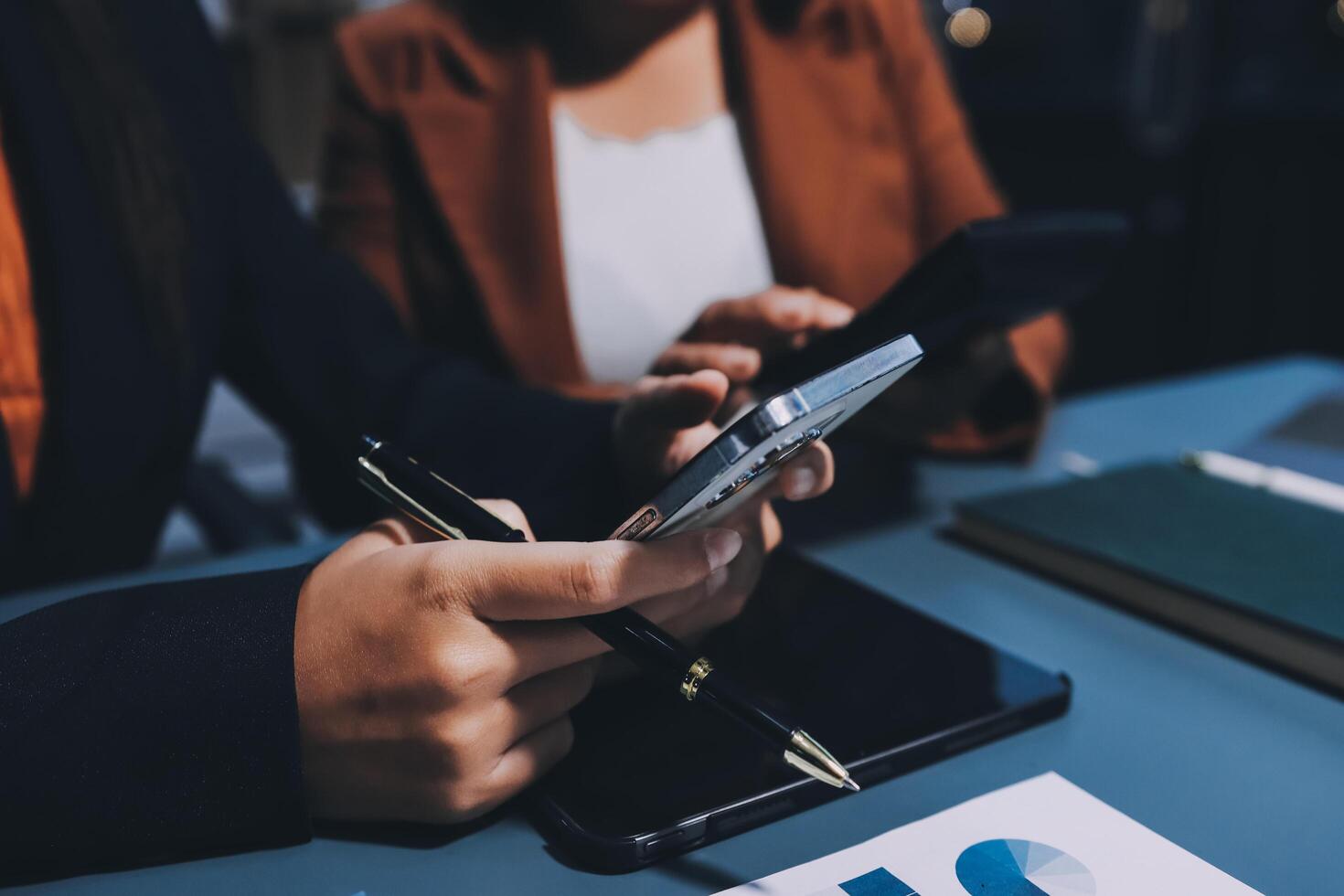 Business people using mobile phones and tablet computers at a desk photo