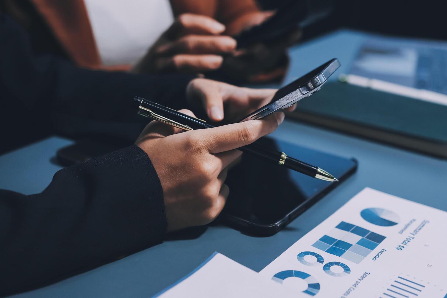 Business people using their smartphones to check their financial data photo