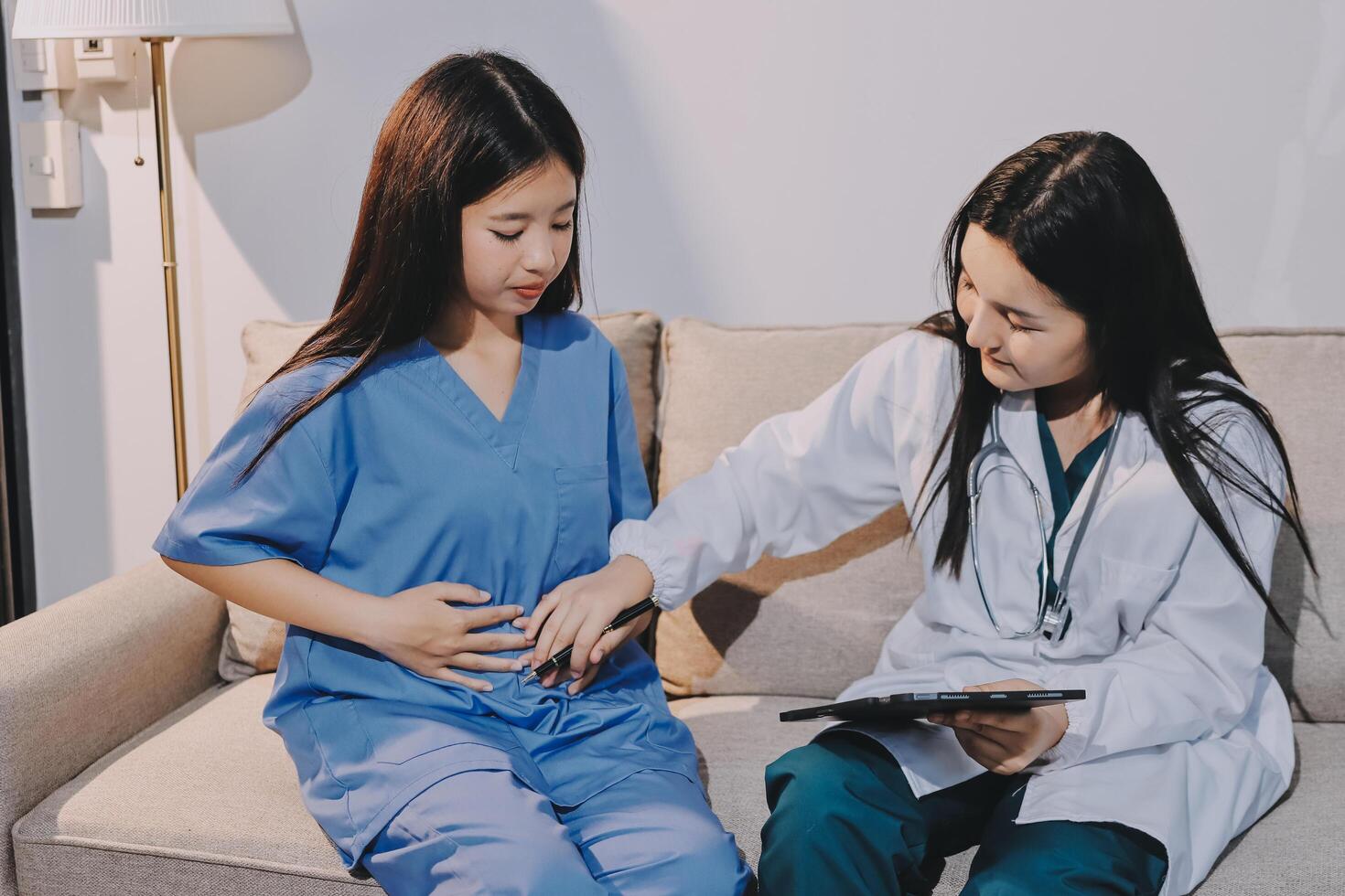 A female doctor is examining a patient's stomach photo