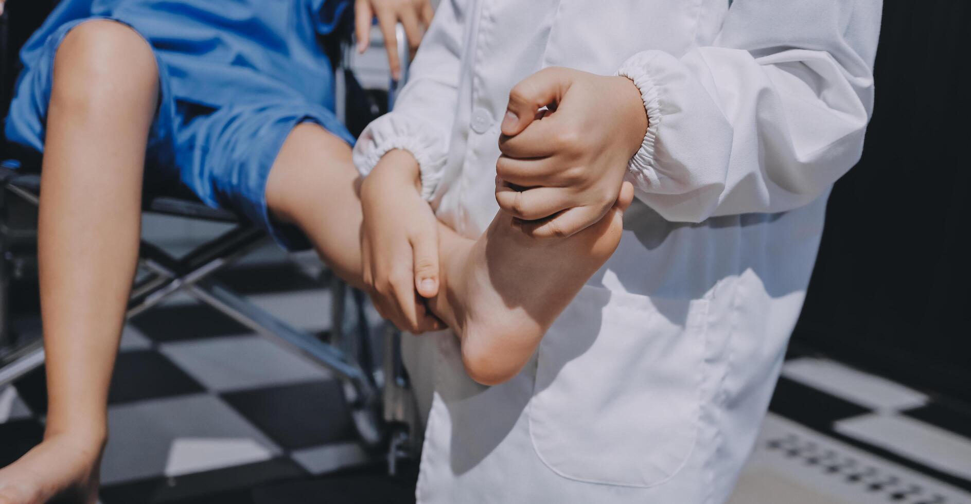 A person in a wheelchair is holding the foot of another person photo