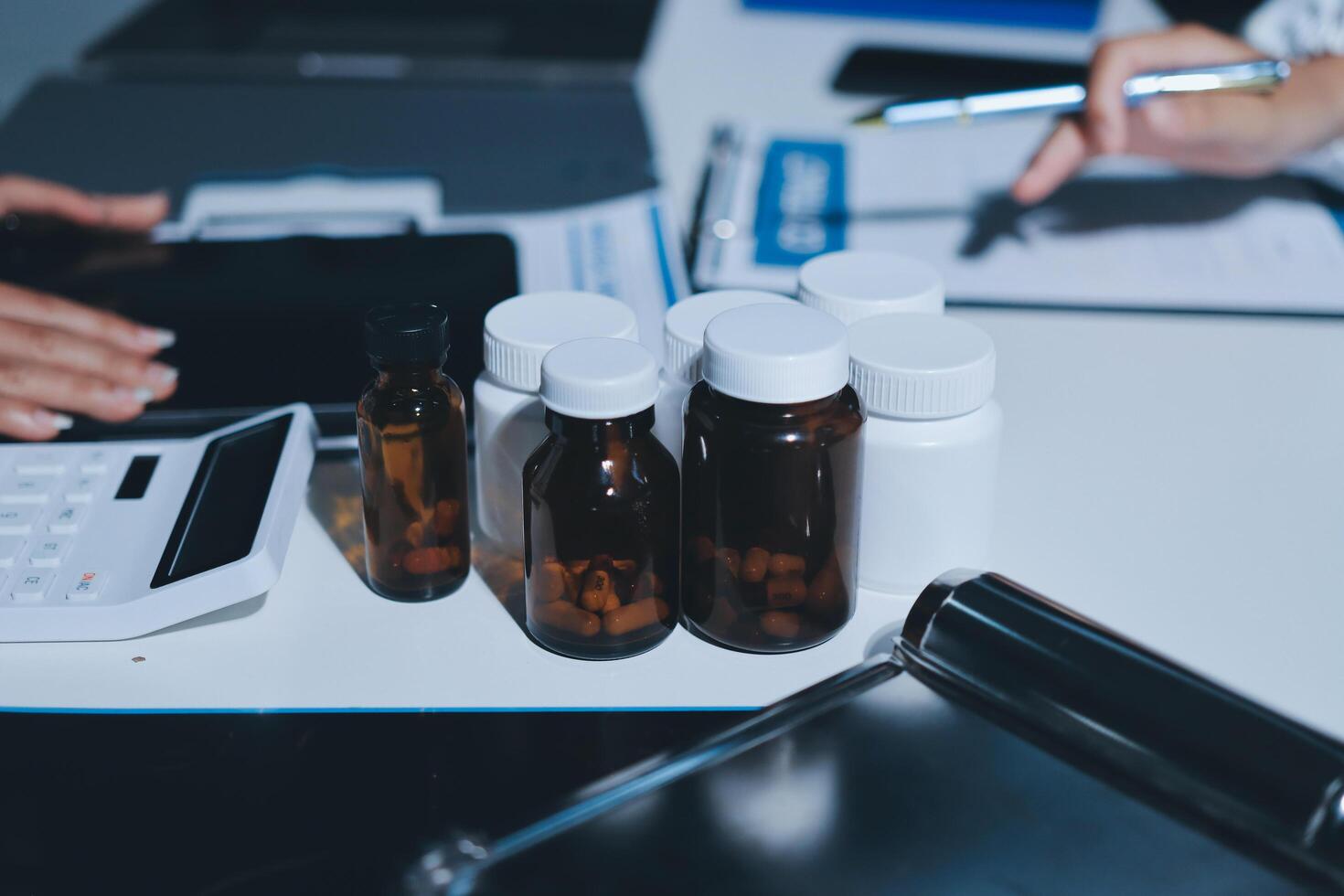 A table with several bottles of medicine and a calculator photo