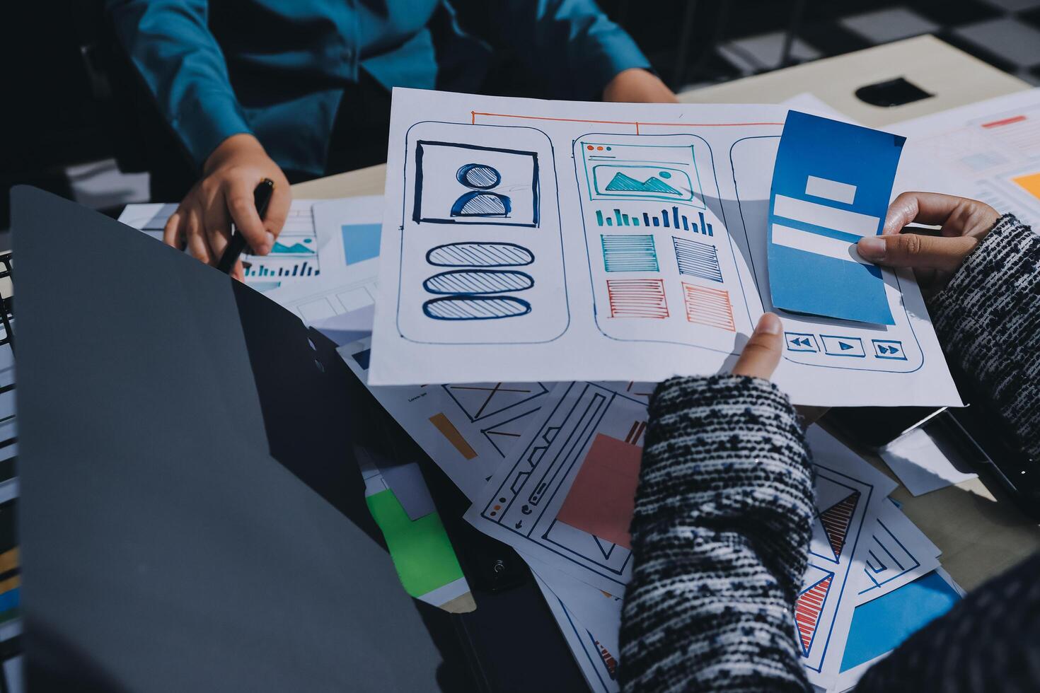 A group of people working on a project with a paper and pen photo
