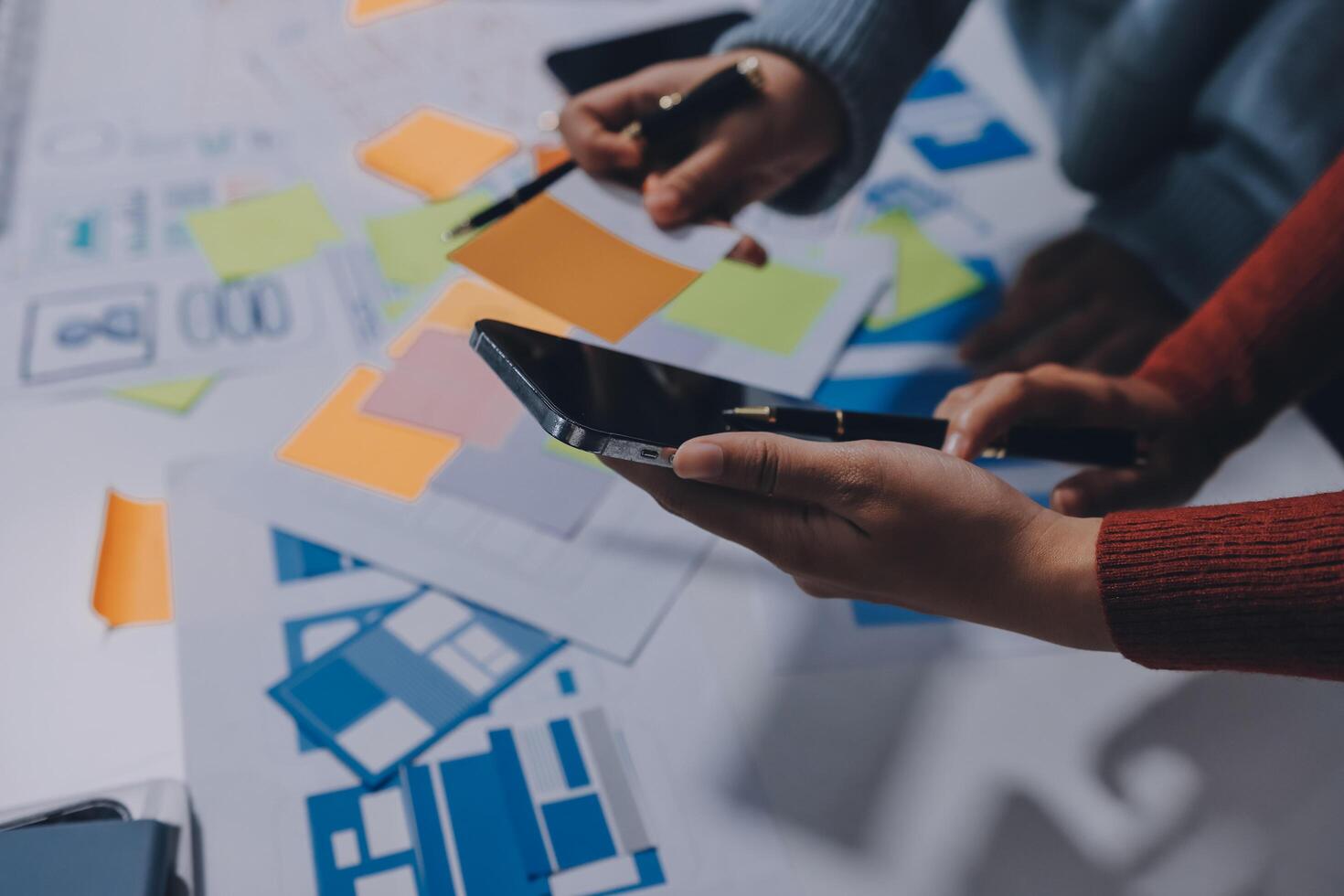 A person is using a smartphone to take notes on a piece of paper photo