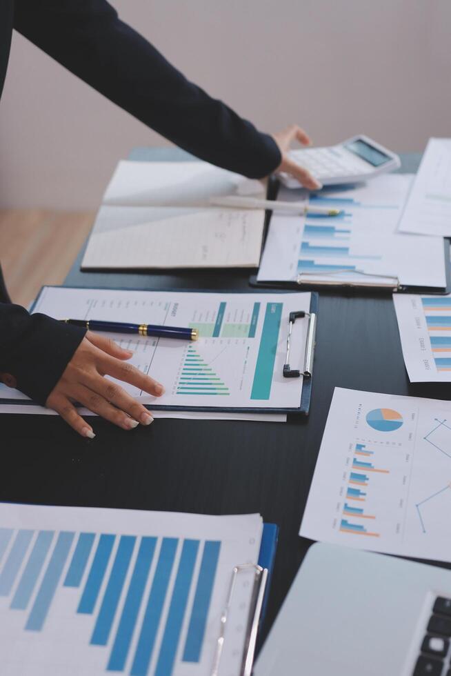 A person is looking at graphs and papers on a table photo