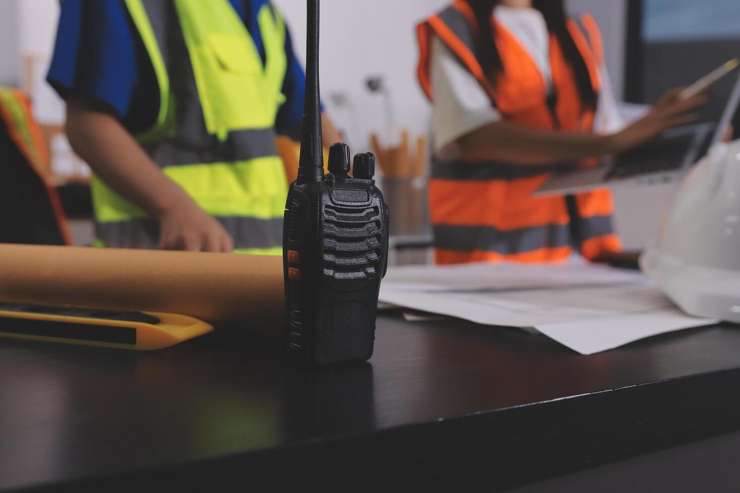 Two people in safety vests standing next to a radio photo