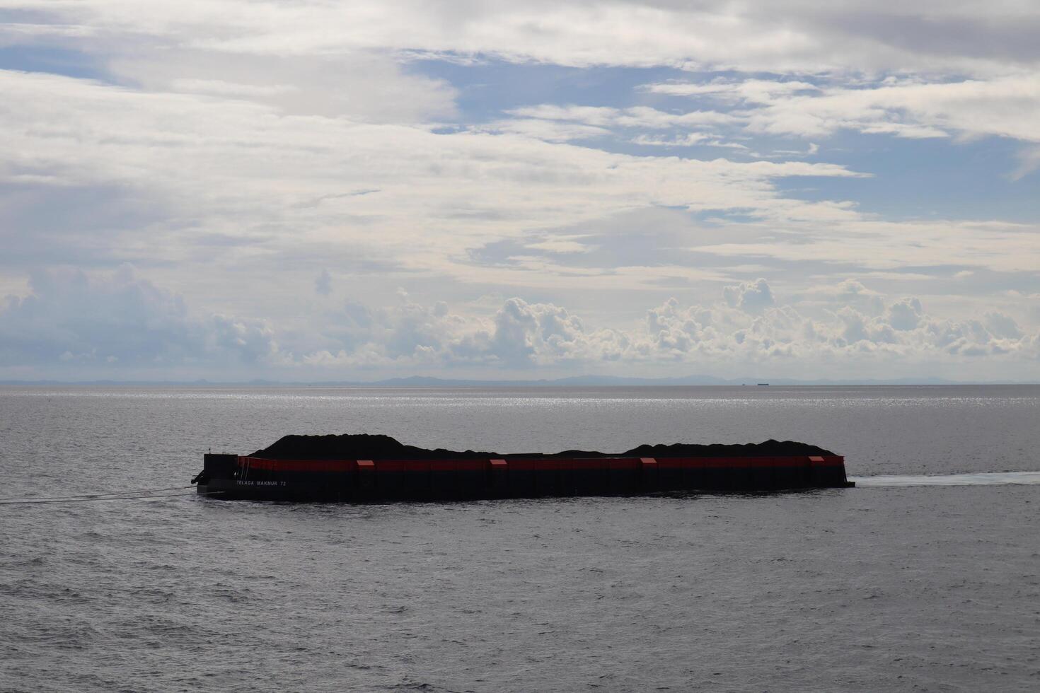 A large boat floating in the ocean with a few people on it photo