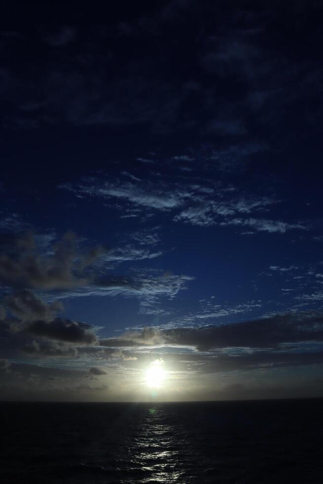 The sun sets over the ocean in this photo