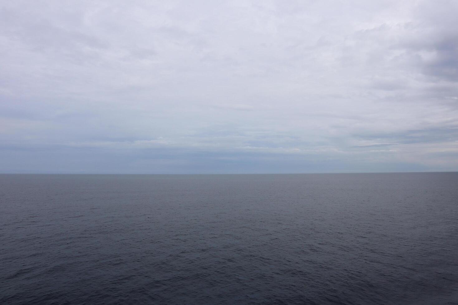 A large body of water with a few clouds photo