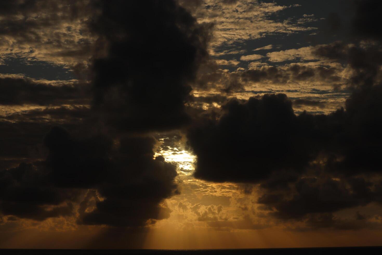 A plane flying over the ocean at sunset photo