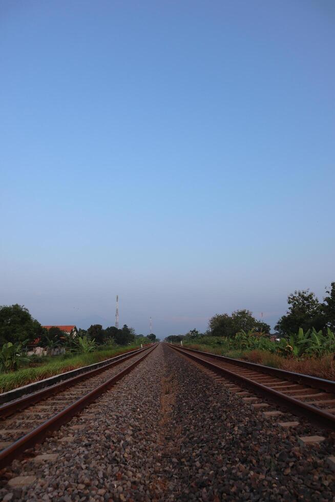 A train going down a track with a sky in the background photo