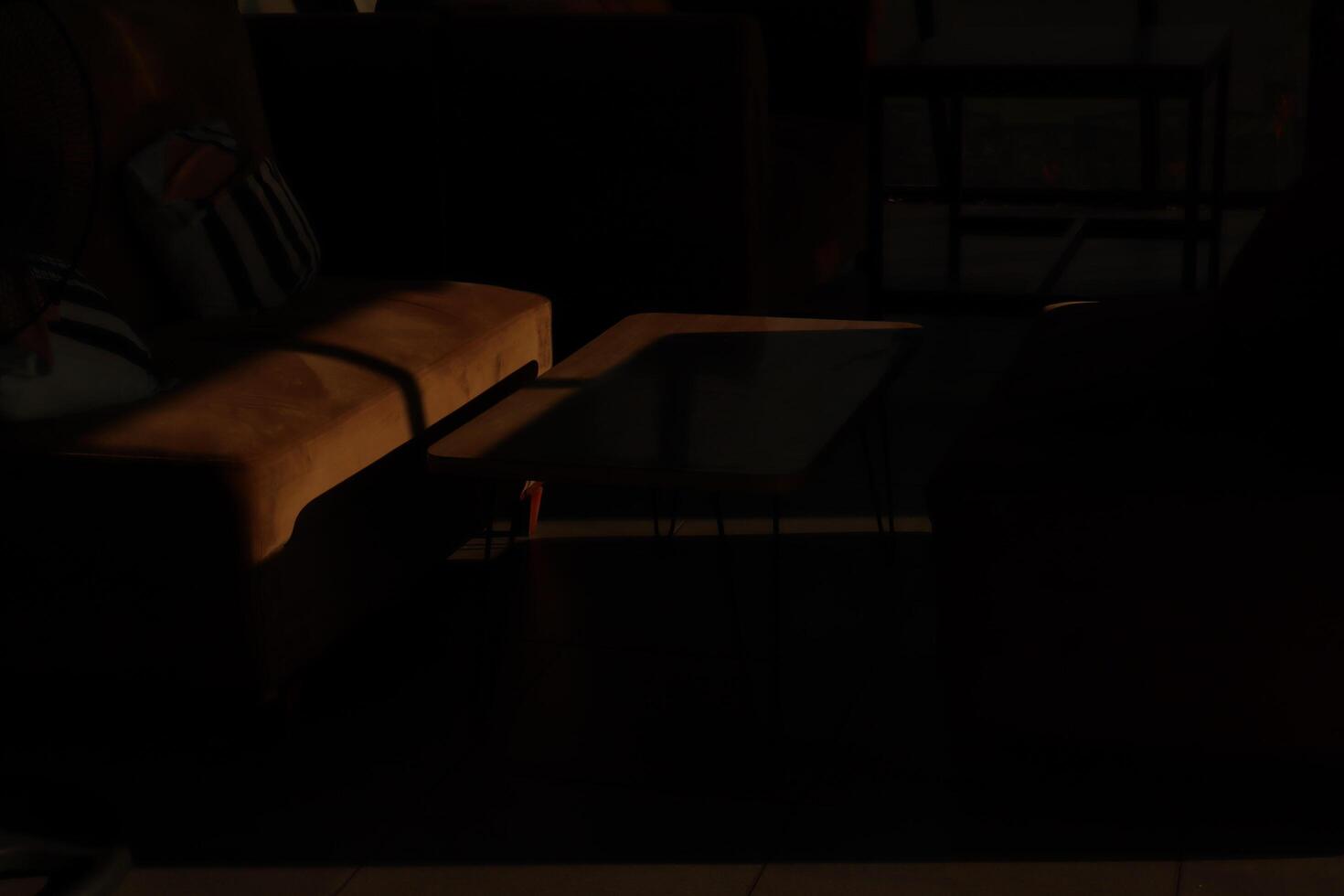 A dark room with a couch and a table photo