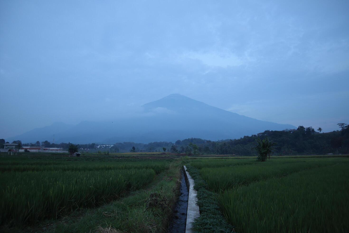 A view of a mountain in the distance with a road photo
