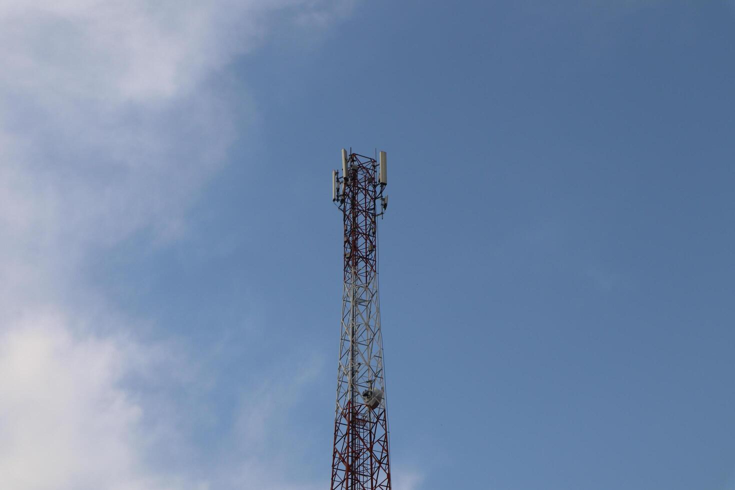 A cell phone tower with a blue sky in the background photo