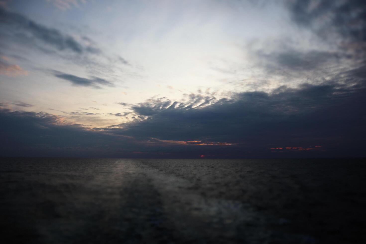 A dark sky with clouds over the ocean photo