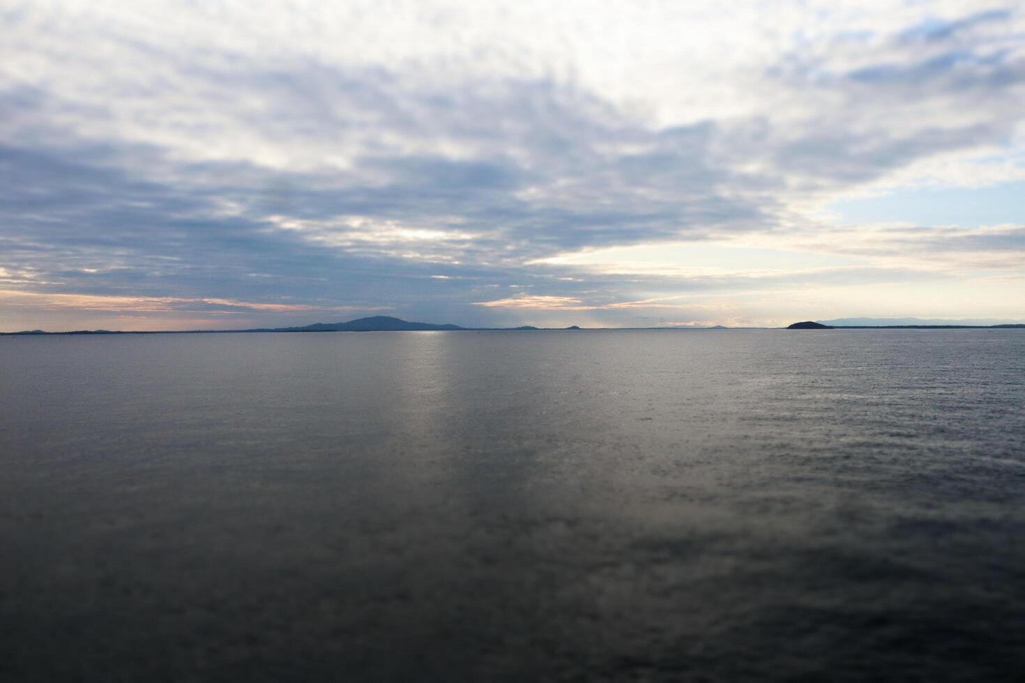 A large body of water with a small island in the distance photo