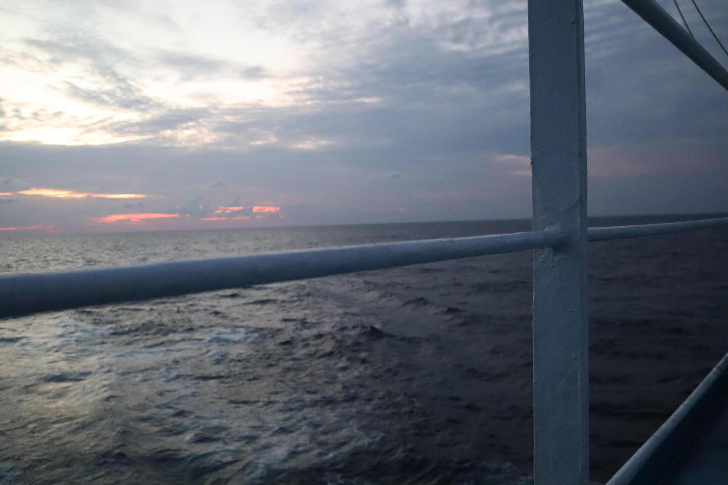 A view of the ocean from a boat at sunset photo