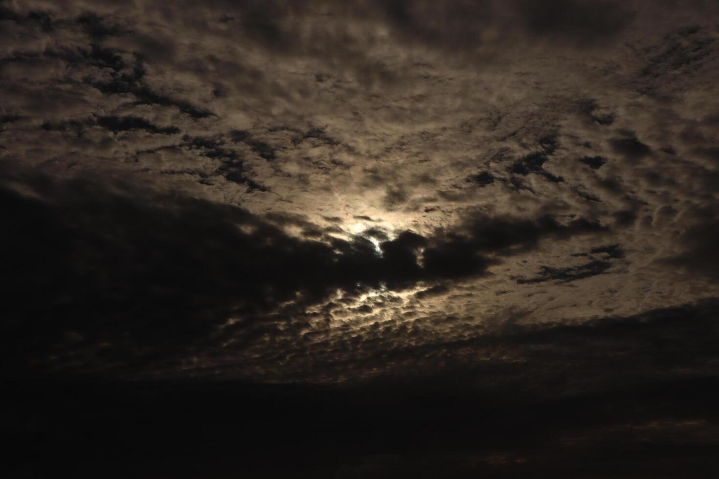 The moon is shining through the clouds in this photo