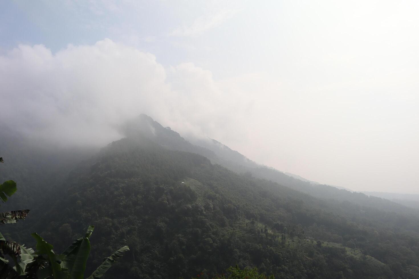 A view of a mountain range with a plane flying over it photo