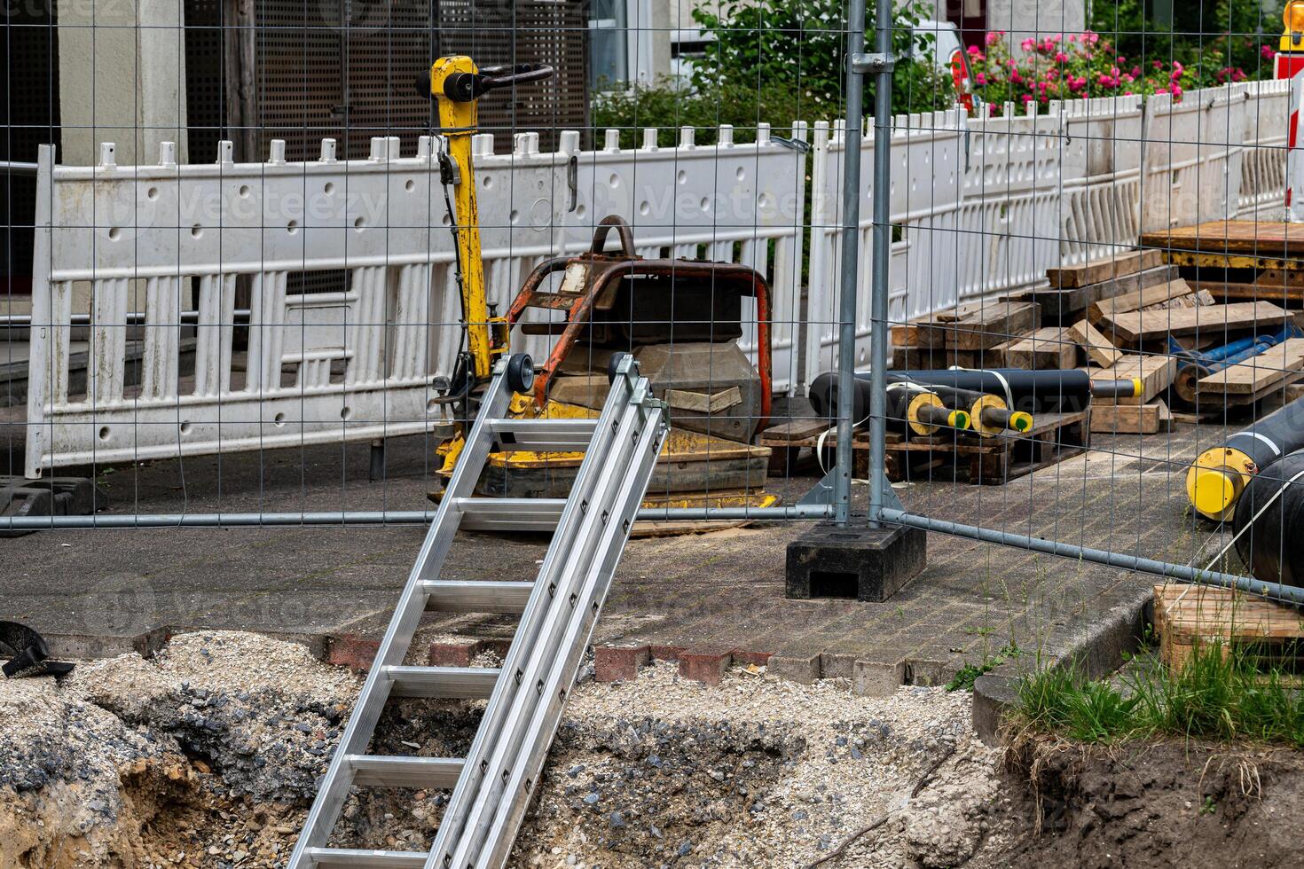 A construction site features a ladder leaning against a fenced area photo