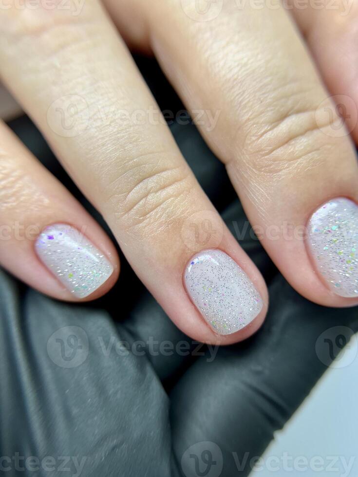 Clean natural manicure on female hand in black glove closeup. photo